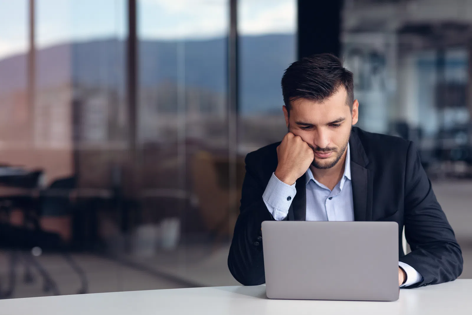 a man sitting at a table with a laptop