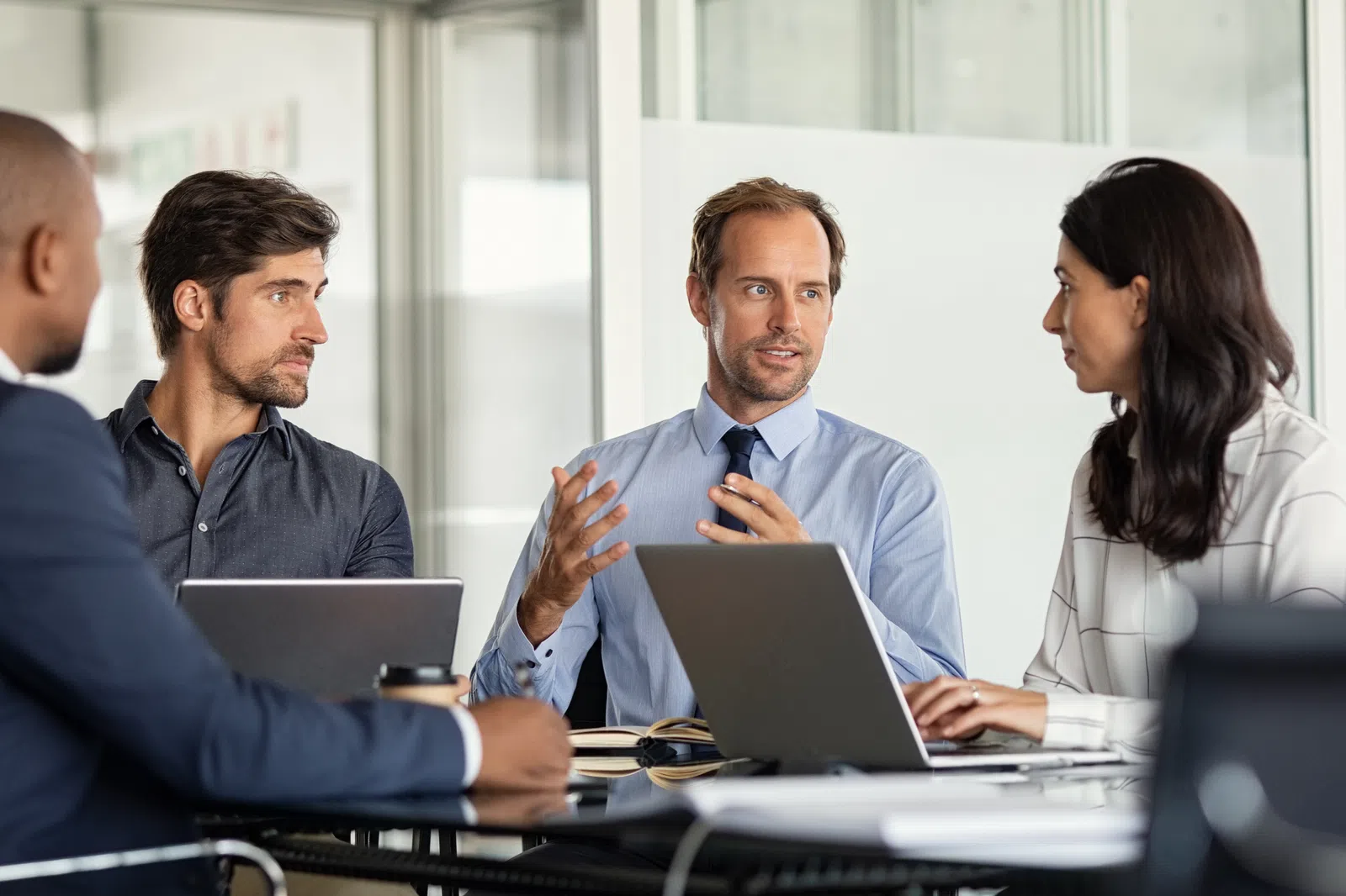 a group of people sitting at a table looking at a laptop